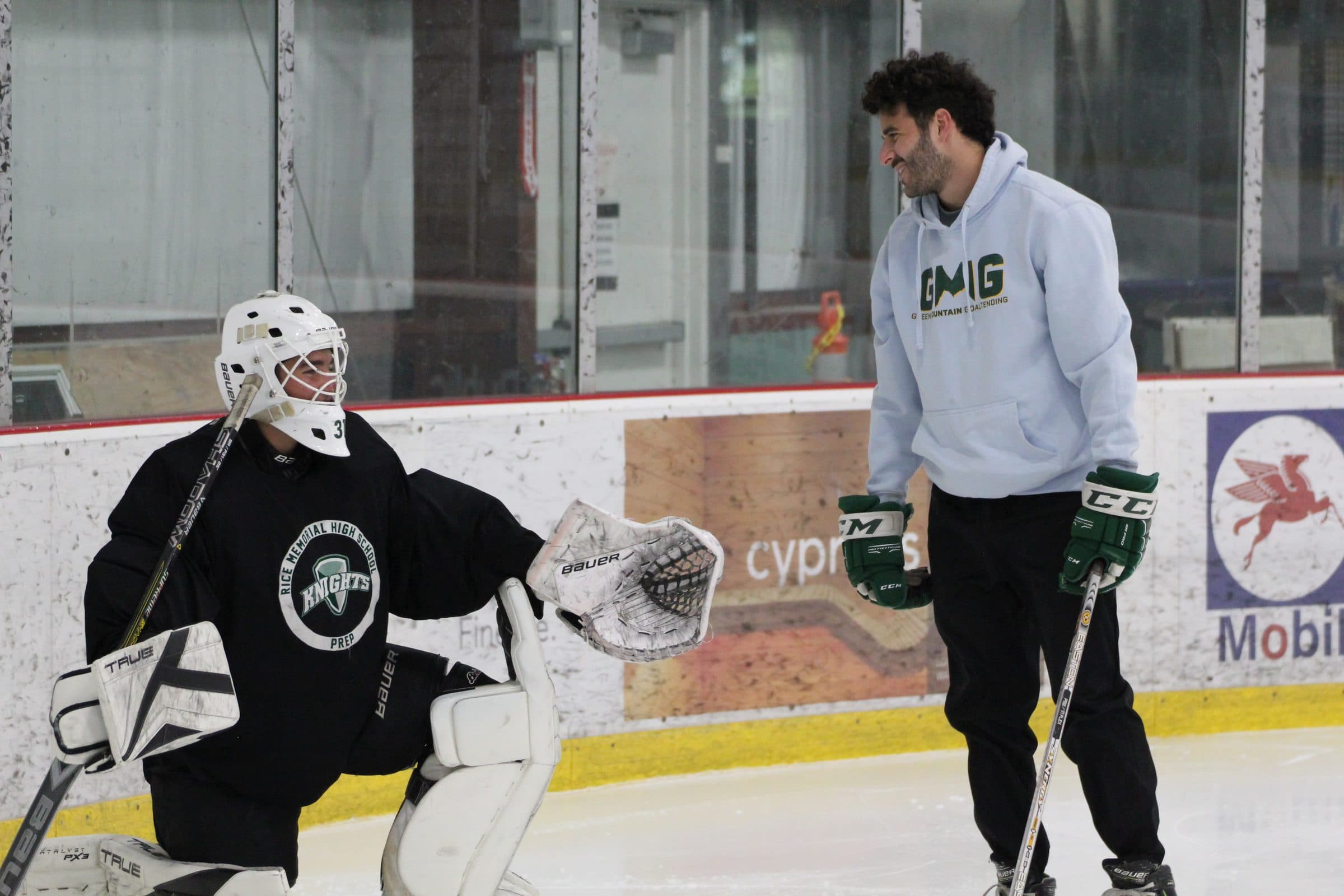 Coach Shea Spanier talking with a prep goalie on the ice
