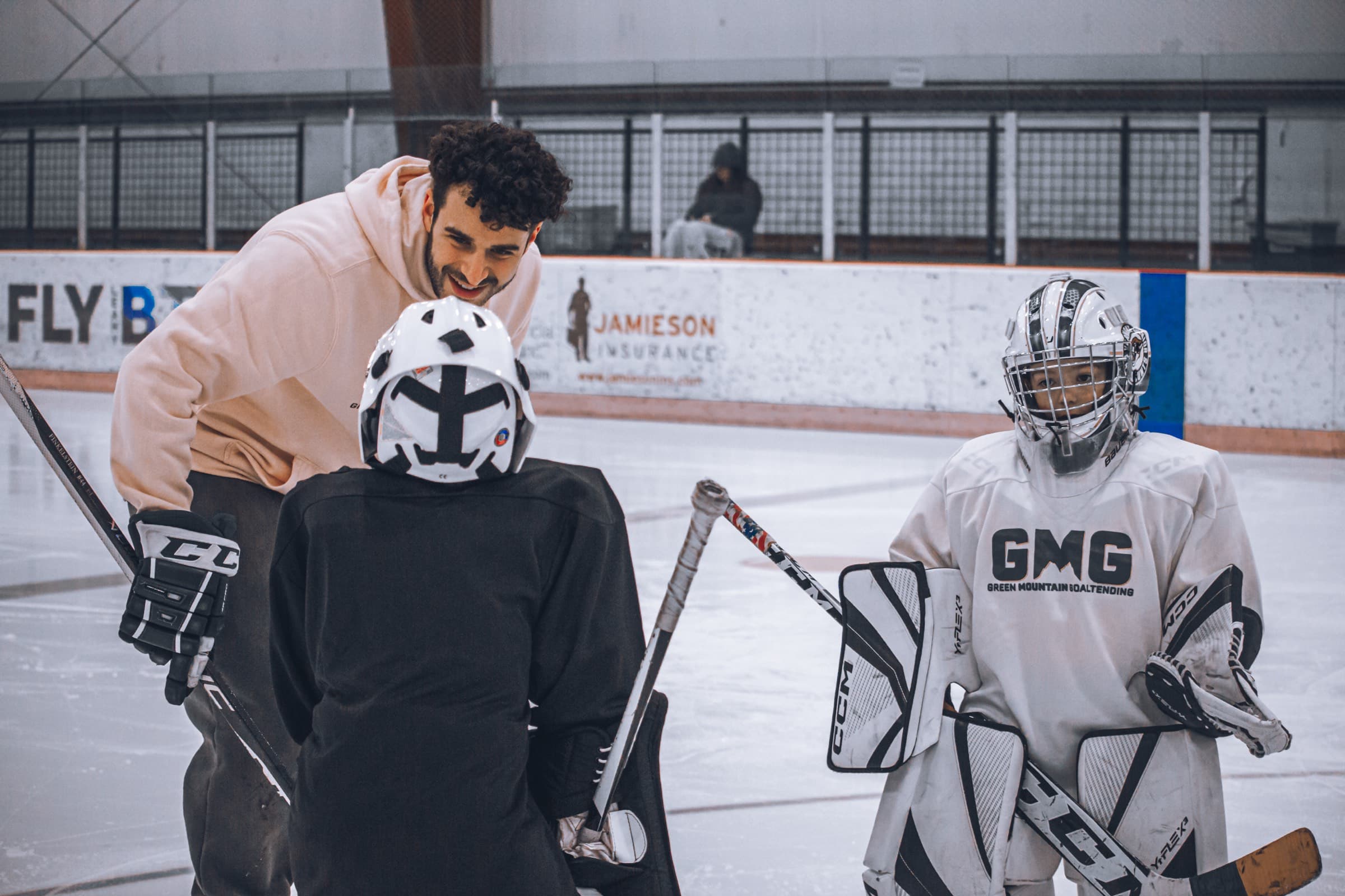 GMG coach working with young goalies on ice